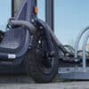 graue Bügelschloss-Verlängerung aus Textil sichert Roller mit Bügelschloss an Fahrradständer ab