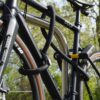 Fahrrad am Hinterrad, Vorderrad und Fahrradrahmen mit D-lock Bügelschloss und eyelet-Textilseil in onyx black am Fahrradständer angeschlossen