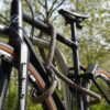Bicycle connected to the rear wheel, front wheel and bicycle frame with D-lock U-lock and eyelet textile cable in wild hemp on the bicycle stand