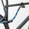 Hinterrad und Oberrohr vom Fahrrad mit Bügelschloss und Verlängerung aus Textil in blau-schwarz am Fahrradständer angeschlossen