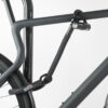 Hinterrad und Oberrohr vom Fahrrad mit Bügelschloss und Verlängerung aus Textil in schwarz am Fahrradständer angeschlossen