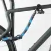Hinterrad und Oberrohr vom Fahrrad mit Bügelschloss und Verlängerung aus Textil in blau-schwarz am Fahrradständer angeschlossen