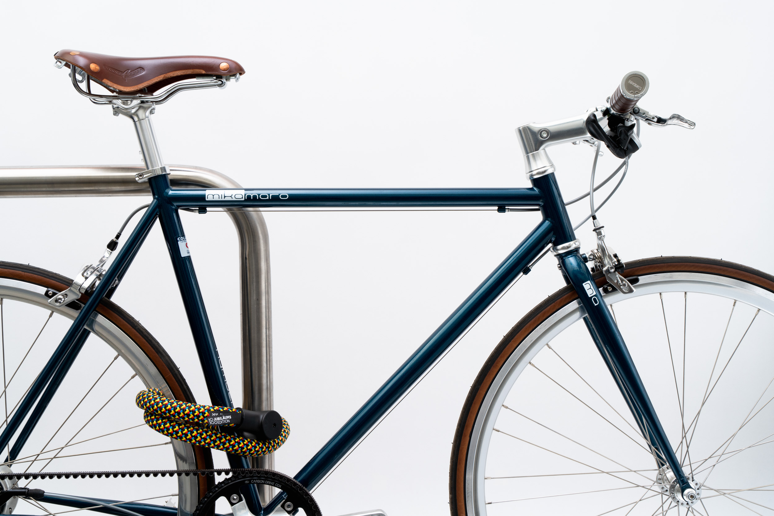 Colourful texlock orbit textile lock secures several bike parts to the bike stand