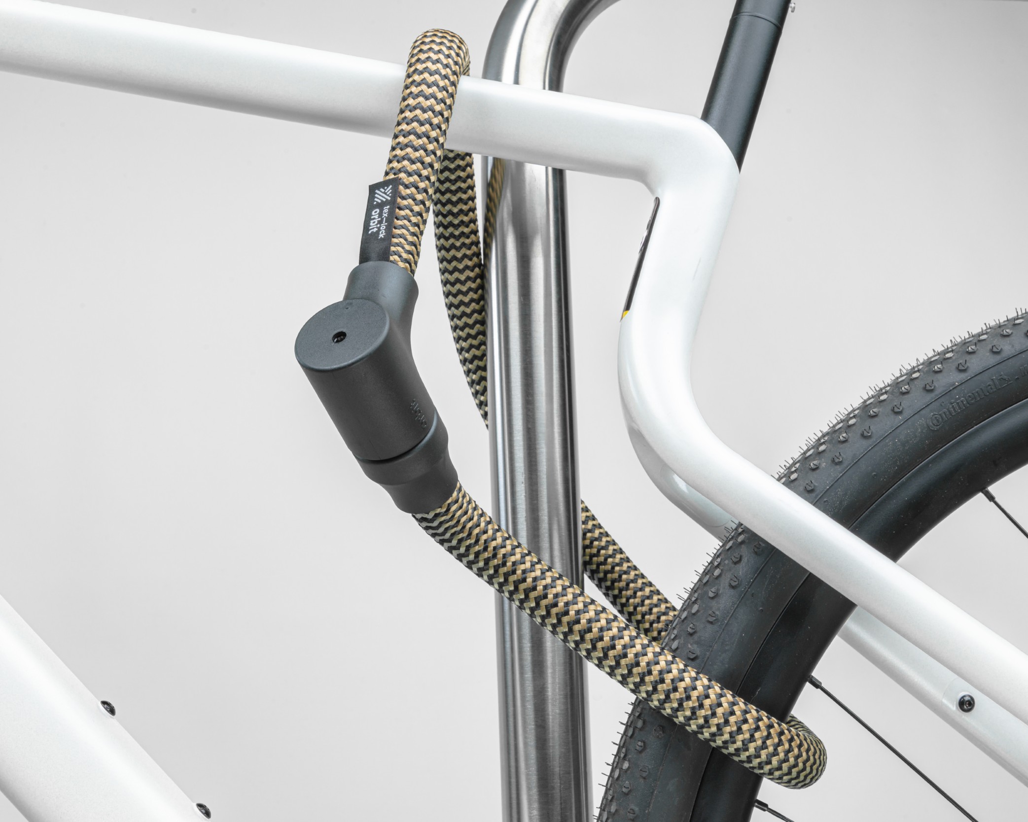 Black and gold texlock orbit textile lock secures several bike parts to the bike stand