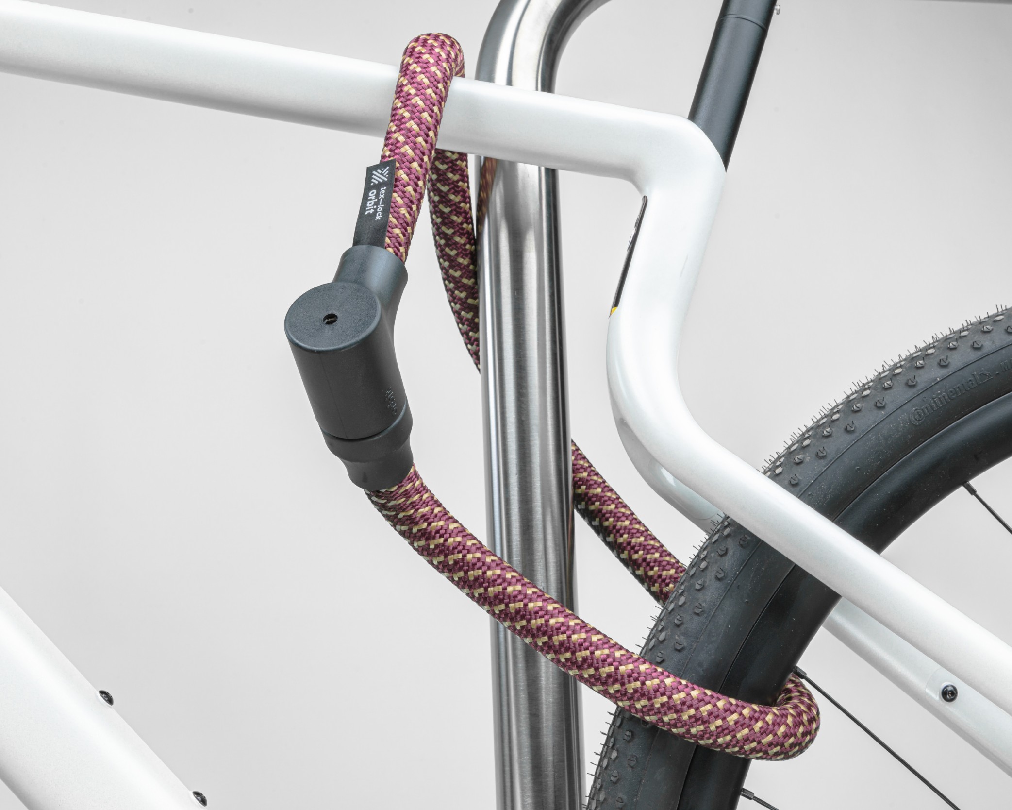 red-gold texlock orbit textile lock secures several bike parts to the bike stand