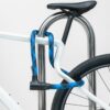 schwarz-blaues texlock orbit Textilschloss sichert mehrere Fahrradteile am Fahrradständer