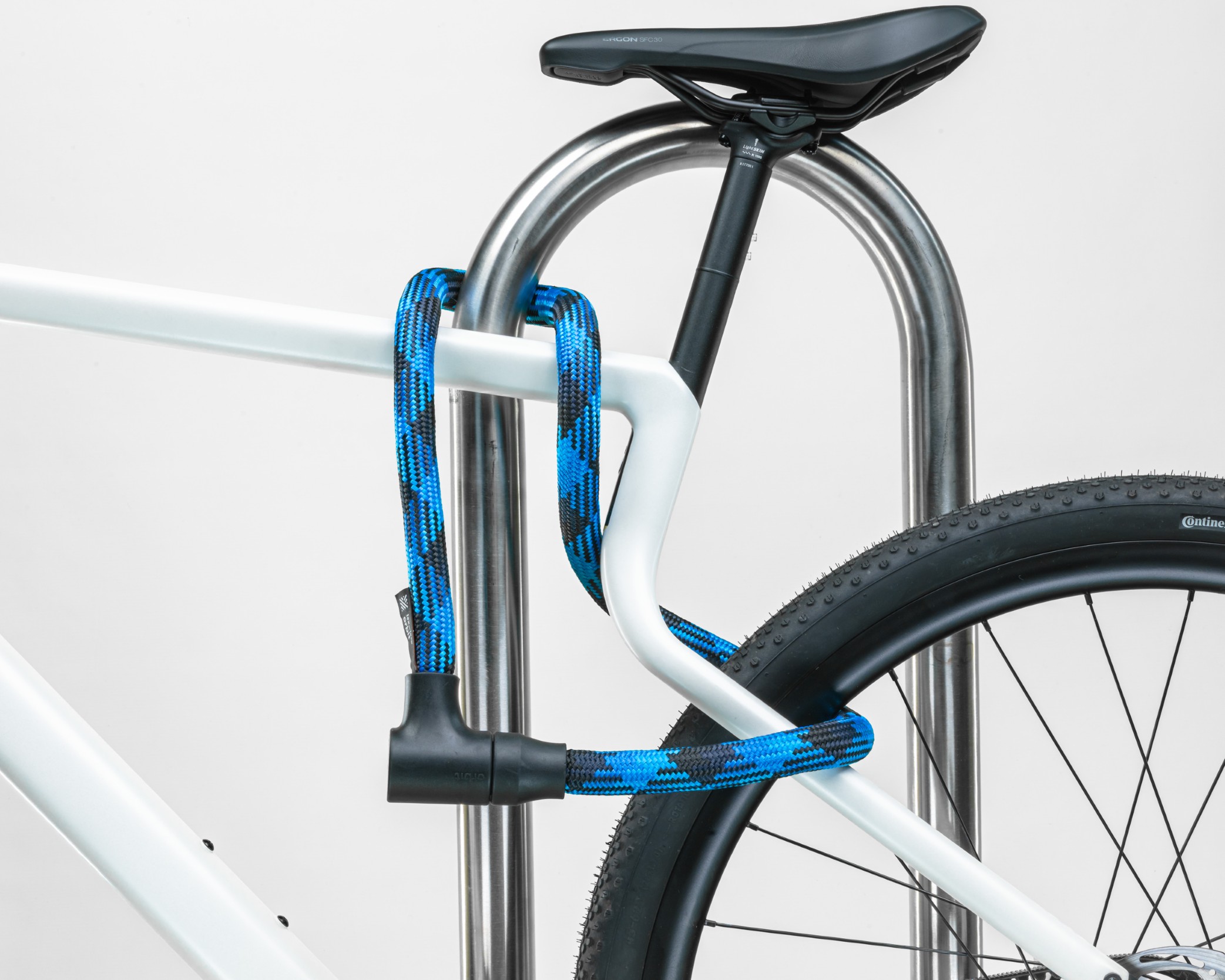 schwarz-blaues texlock orbit Textilschloss sichert mehrere Fahrradteile am Fahrradständer