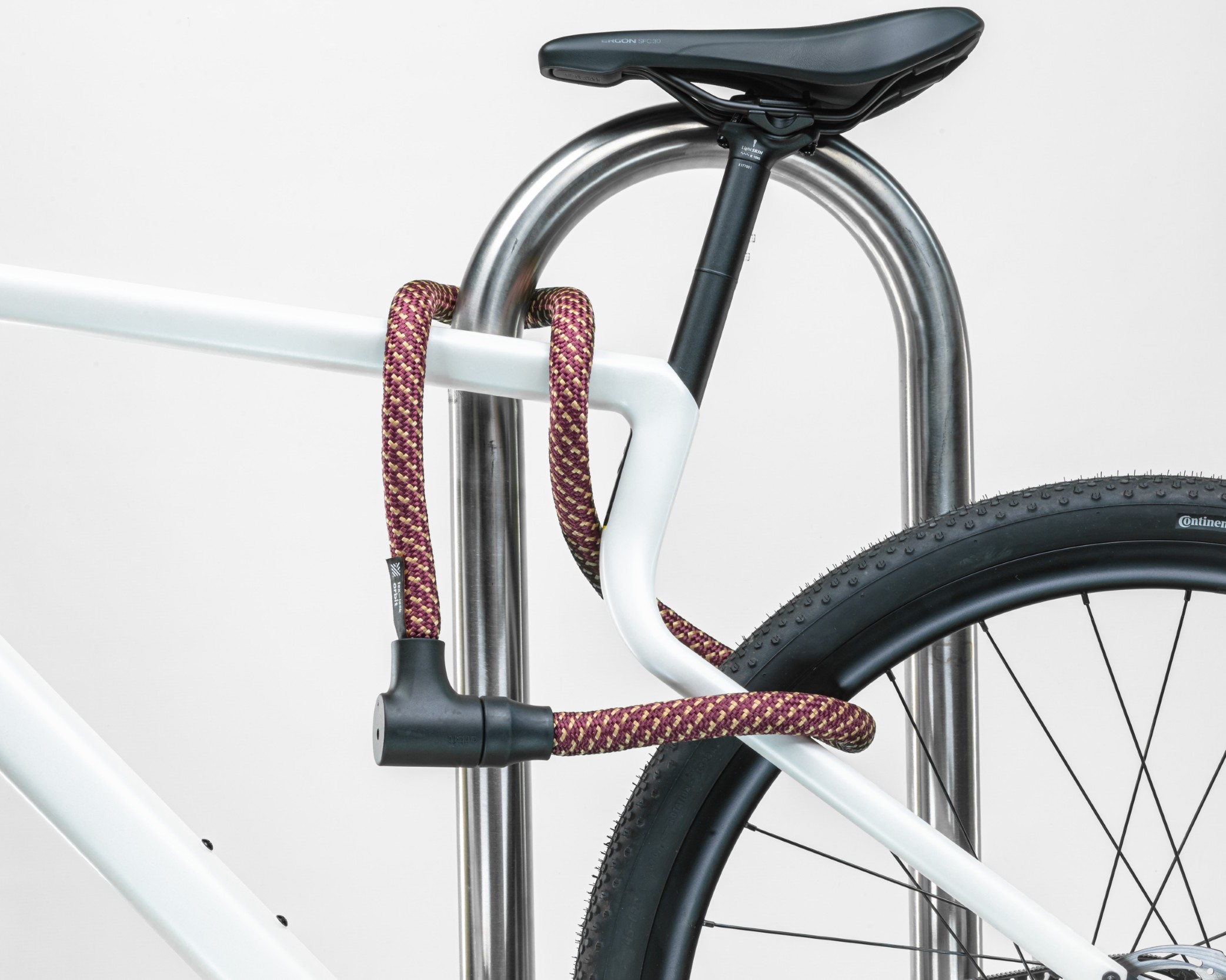 red-gold texlock orbit textile lock secures several bike parts to the bike stand