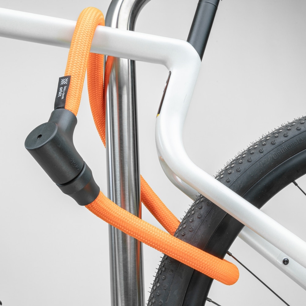 orangenes texlock orbit Textilschloss sichert mehrere Fahrradteile am Fahrradständer